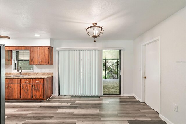 kitchen with a textured ceiling, hardwood / wood-style flooring, and sink