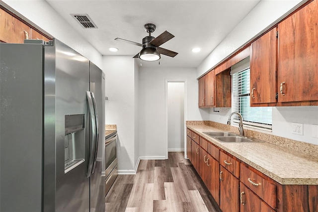 kitchen with hardwood / wood-style floors, ceiling fan, sink, and stainless steel appliances