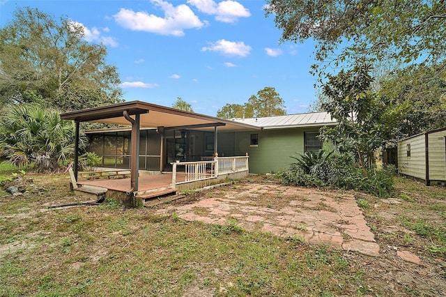 rear view of house with a sunroom and a deck