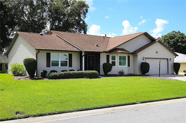 single story home with a garage and a front lawn