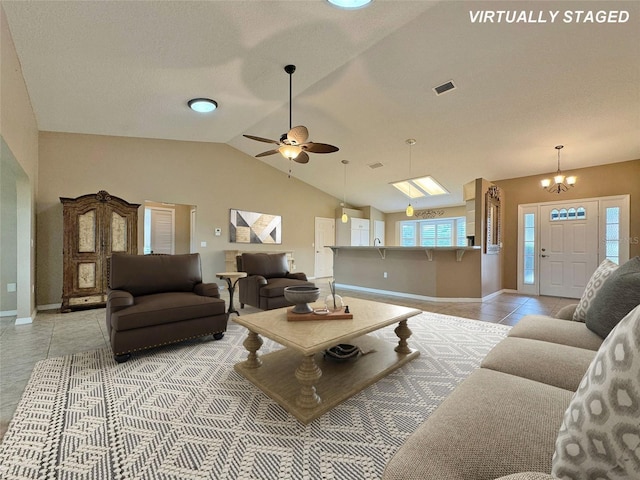 living room with baseboards, visible vents, light tile patterned flooring, vaulted ceiling, and ceiling fan with notable chandelier