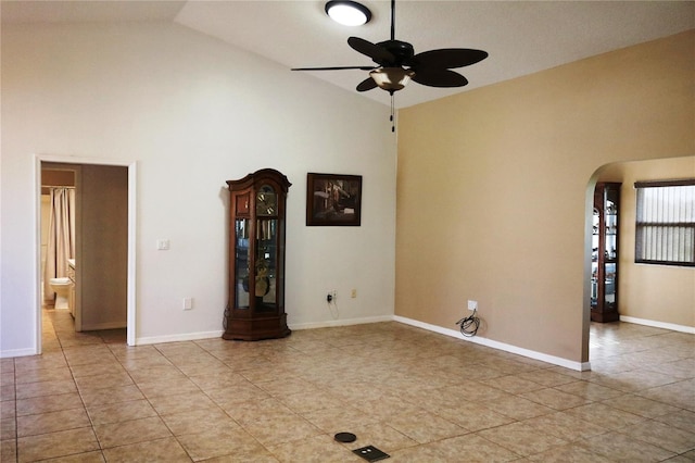 tiled empty room with ceiling fan and high vaulted ceiling