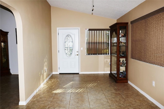 entrance foyer featuring a textured ceiling and vaulted ceiling