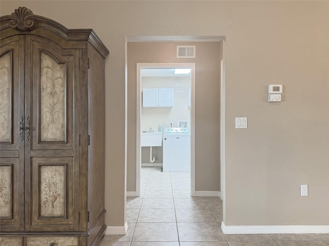 hall featuring light tile patterned floors and washer / clothes dryer