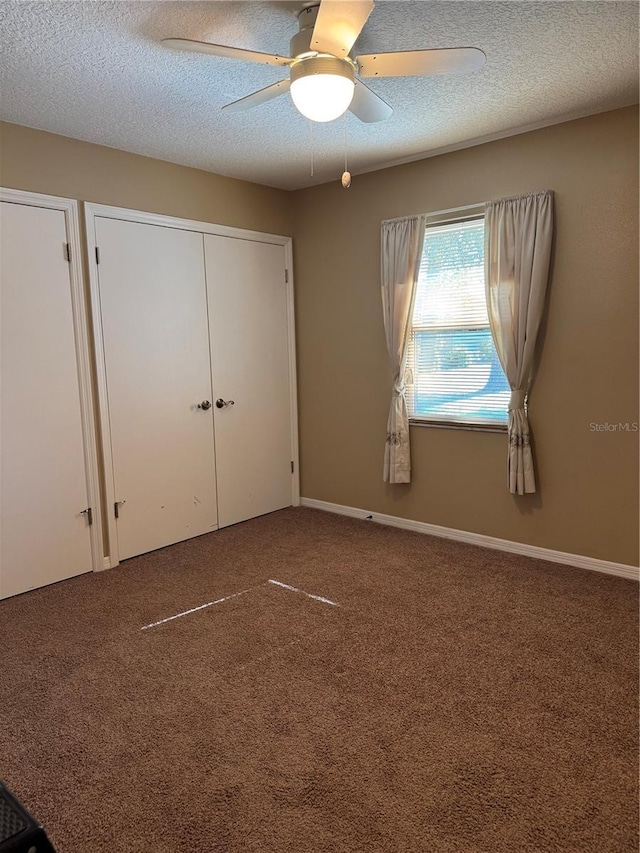 unfurnished bedroom featuring ceiling fan, carpet floors, and a textured ceiling