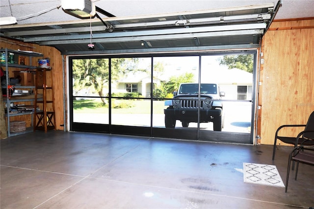 garage with a garage door opener and wooden walls