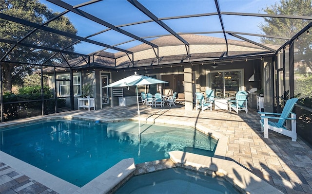 view of swimming pool with an in ground hot tub, a patio area, and a lanai