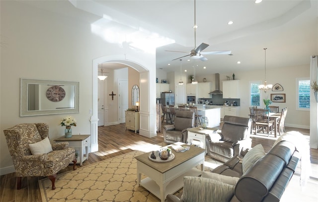 living room with light hardwood / wood-style flooring and ceiling fan with notable chandelier