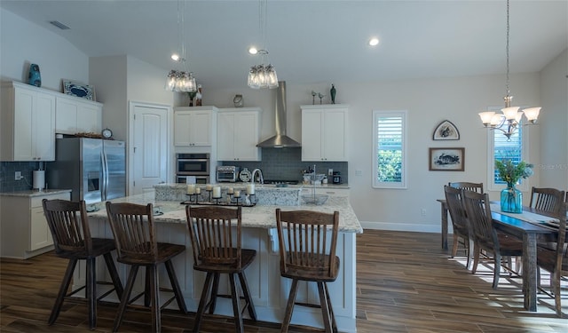 kitchen featuring white cabinetry, wall chimney exhaust hood, dark hardwood / wood-style flooring, and a center island with sink