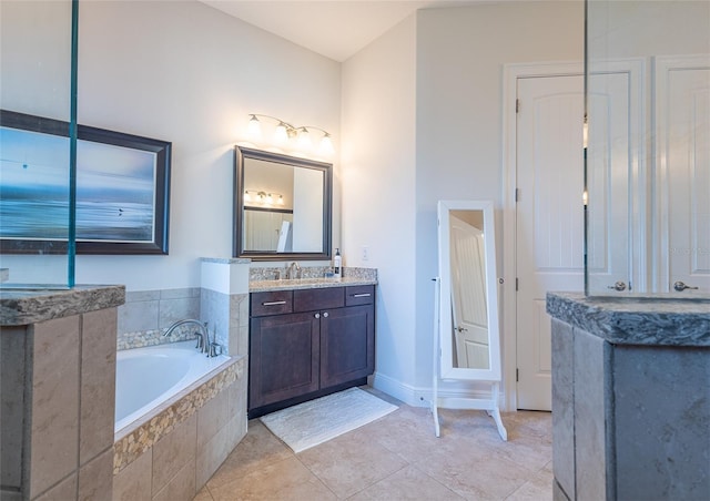 bathroom featuring vanity, tiled tub, and tile patterned flooring