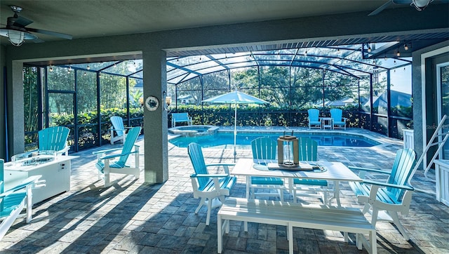 view of swimming pool featuring a patio, a lanai, an in ground hot tub, and ceiling fan