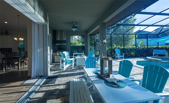 view of patio featuring a lanai, an in ground hot tub, and ceiling fan