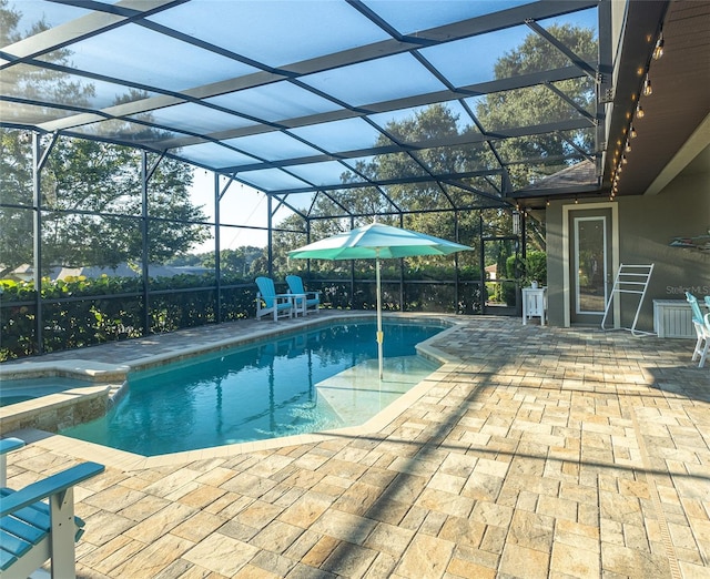 view of pool with a patio, an in ground hot tub, and a lanai