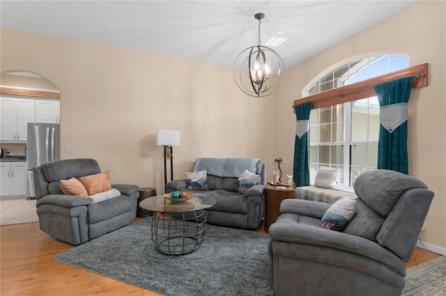 living room with light hardwood / wood-style floors and a notable chandelier