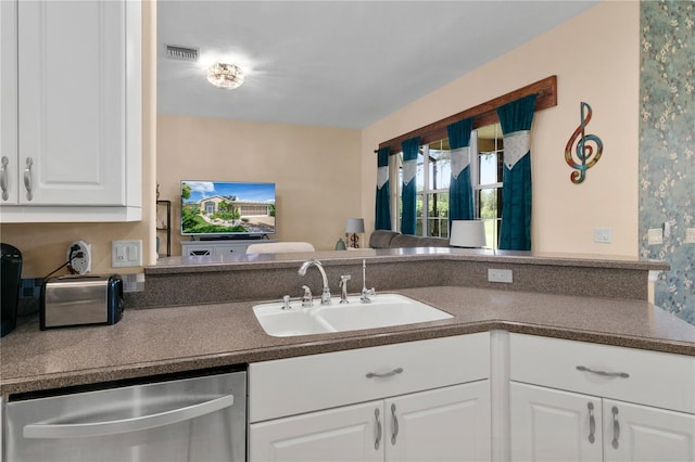 kitchen with dishwasher, sink, and white cabinetry