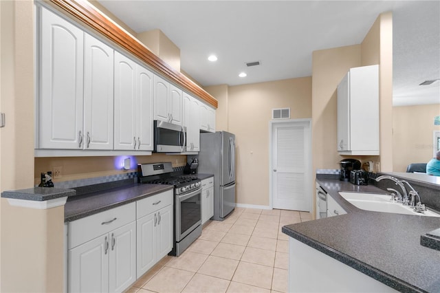 kitchen with light tile patterned floors, white cabinets, appliances with stainless steel finishes, and sink