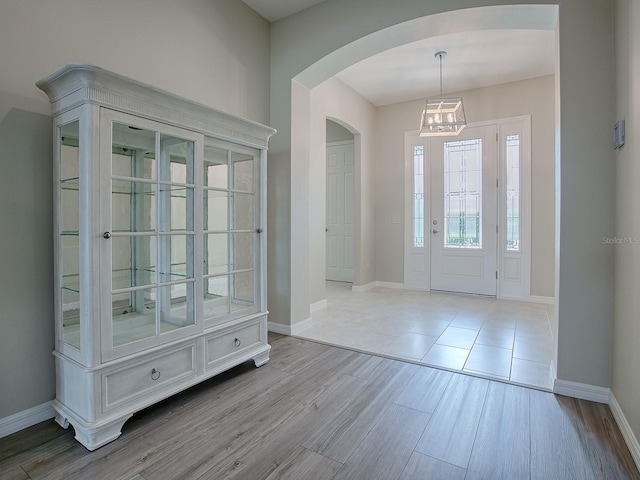 entrance foyer featuring light wood-type flooring and a notable chandelier