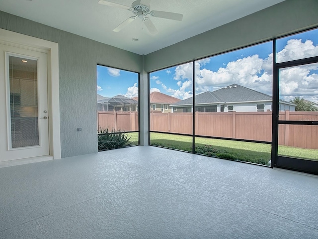 unfurnished sunroom with ceiling fan