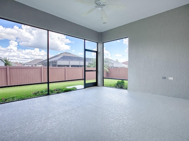 unfurnished sunroom with ceiling fan