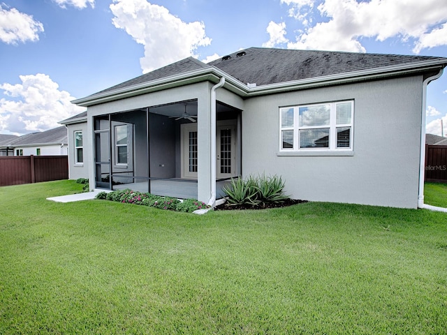 back of property featuring a sunroom and a yard