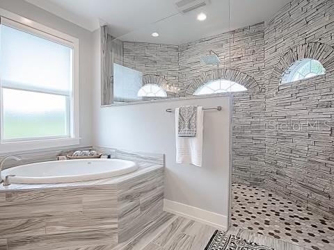 bathroom featuring hardwood / wood-style flooring, separate shower and tub, and a wealth of natural light