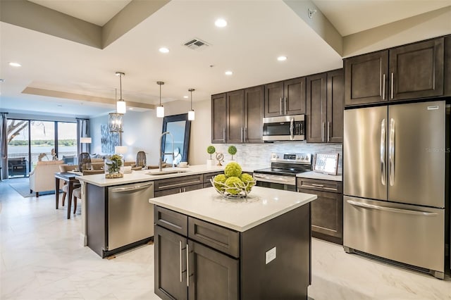 kitchen featuring sink, a kitchen island, decorative backsplash, appliances with stainless steel finishes, and dark brown cabinetry