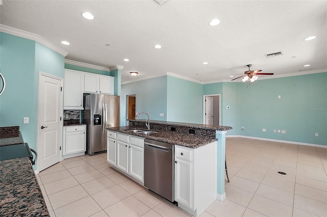 kitchen featuring appliances with stainless steel finishes, dark stone counters, ceiling fan, sink, and white cabinets