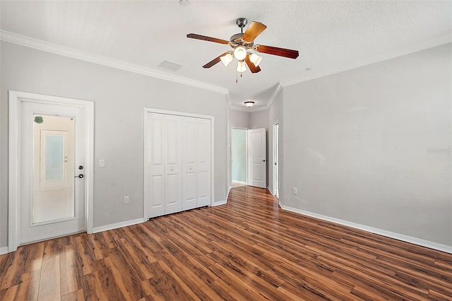 unfurnished bedroom with crown molding, ceiling fan, dark hardwood / wood-style floors, a textured ceiling, and a closet