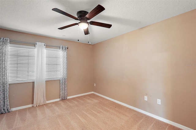 empty room with a textured ceiling, light colored carpet, and ceiling fan