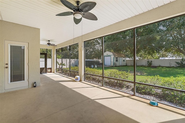 unfurnished sunroom with ceiling fan