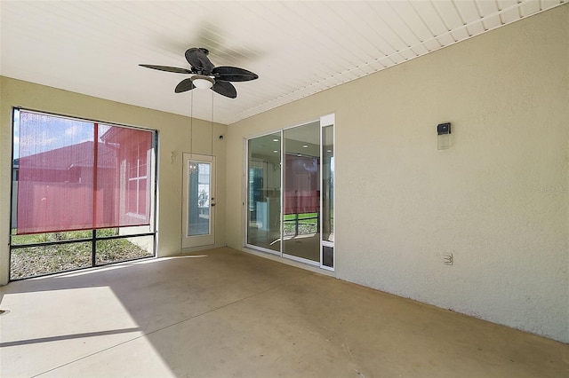 unfurnished sunroom featuring ceiling fan and a wealth of natural light