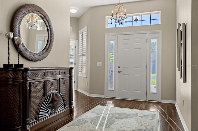 foyer entrance featuring dark hardwood / wood-style flooring and an inviting chandelier