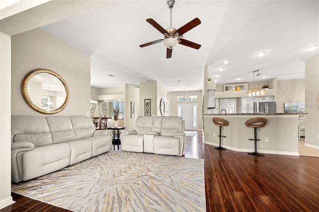 living room with lofted ceiling, a textured ceiling, wood-type flooring, and ceiling fan