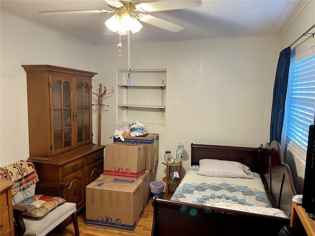 bedroom with a textured ceiling, ornamental molding, ceiling fan, and light hardwood / wood-style flooring