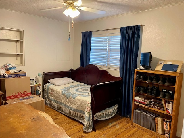 bedroom with wood-type flooring, ceiling fan, and a textured ceiling