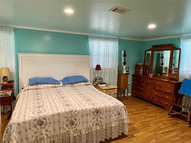 bedroom with light wood-type flooring and ornamental molding