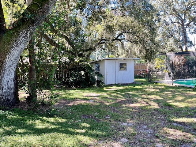 view of yard featuring a fenced in pool and a shed