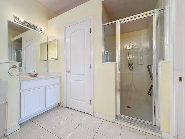 bathroom featuring tile patterned flooring, an enclosed shower, and vanity