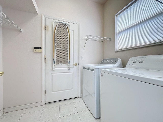 laundry area with washer and clothes dryer and light tile patterned floors