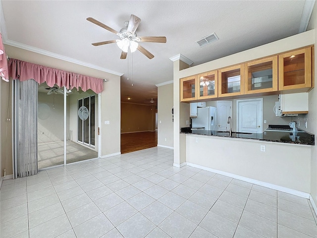 kitchen featuring ceiling fan, ornamental molding, light tile patterned floors, and white refrigerator with ice dispenser