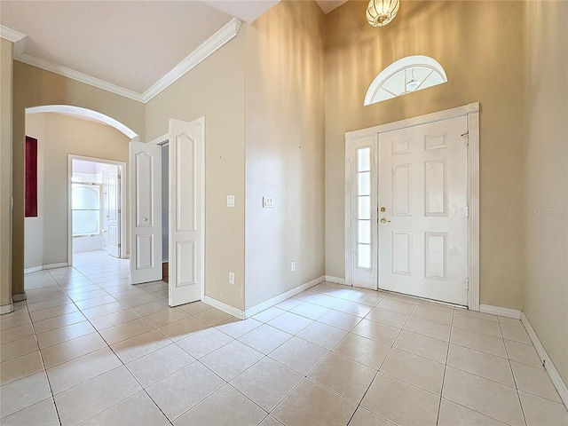 tiled entryway with a high ceiling, plenty of natural light, and crown molding