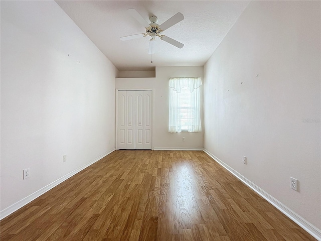 unfurnished room with a textured ceiling, wood-type flooring, and ceiling fan