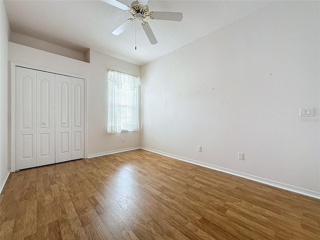 unfurnished bedroom with hardwood / wood-style flooring, ceiling fan, a textured ceiling, and a closet