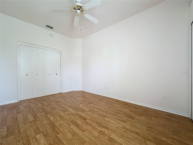 unfurnished bedroom with hardwood / wood-style flooring, ceiling fan, and a closet