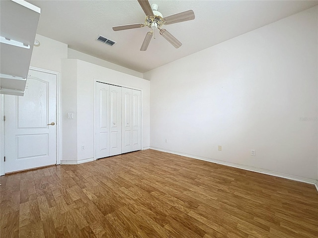 unfurnished bedroom featuring ceiling fan, a closet, and wood-type flooring