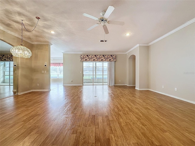 unfurnished living room with hardwood / wood-style flooring, ceiling fan with notable chandelier, a textured ceiling, and crown molding