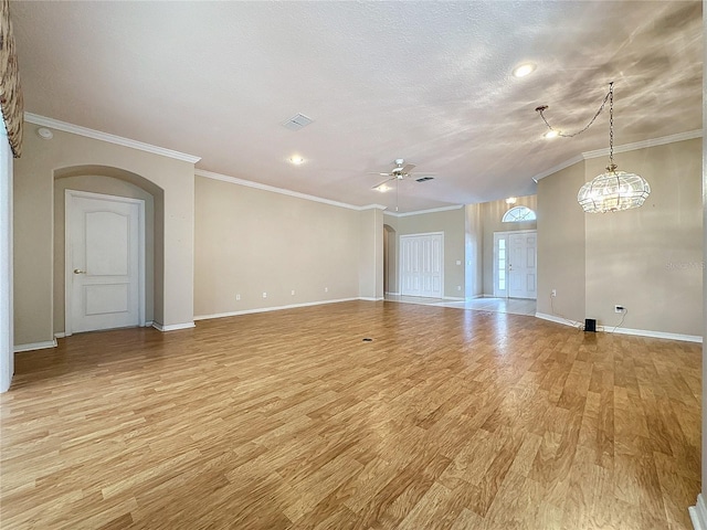 unfurnished room featuring ceiling fan with notable chandelier, light hardwood / wood-style flooring, a textured ceiling, and crown molding