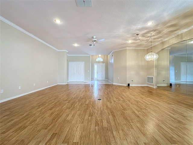 unfurnished living room with a textured ceiling, hardwood / wood-style floors, ornamental molding, and ceiling fan with notable chandelier