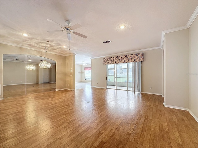 unfurnished room with ornamental molding, ceiling fan with notable chandelier, wood-type flooring, and a textured ceiling