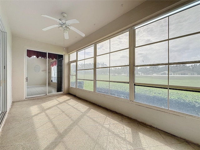 unfurnished sunroom with ceiling fan